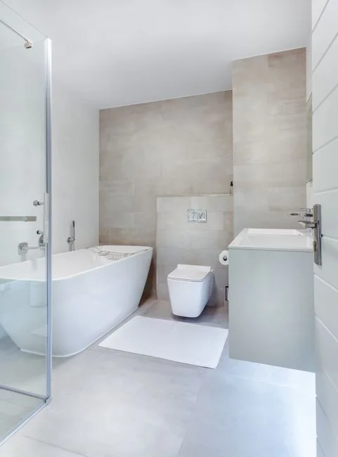 Anonymous person in yellow rubber gloves using simple sponge for cleaning mirror in bathroom